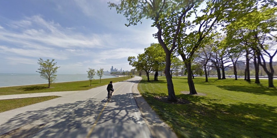 A paved bike and running path along Lake Michigan in the summer.