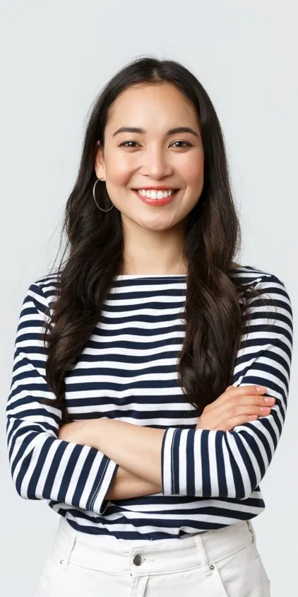 A smiling female prospective resident with arms folded in a black and white striped shirt.