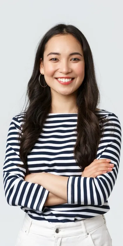 A smiling female prospective resident with arms folded in a black and white striped shirt.