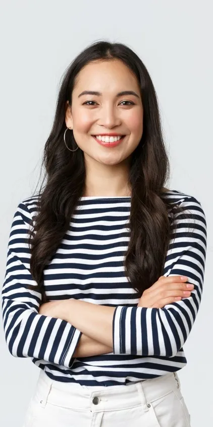 A smiling female prospective resident with arms folded in a black and white striped shirt.