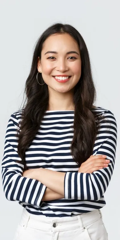 A smiling female prospective resident with arms folded in a black and white striped shirt.