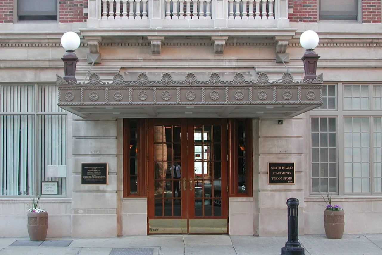 The historic main entrance to the 57 unit senior restricted North Island Apartments in limestone and wood.