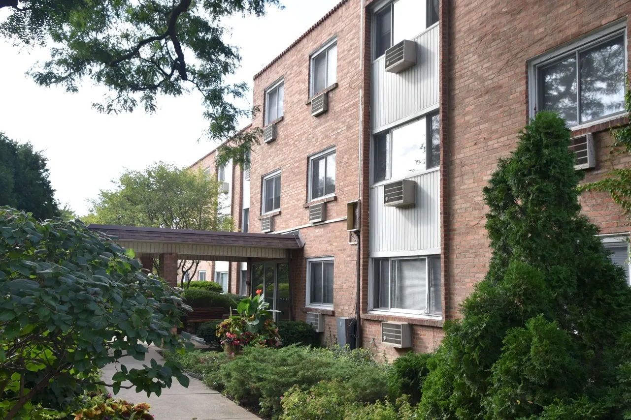 Exterior of Lotus Garden Apartments a one hundred and twenty unit three story mid century brick property with nicely landscaped grounds in Skokie.