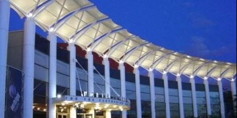 North Shore Center for the Performing Arts colonnade at night with dramatic uplighting.