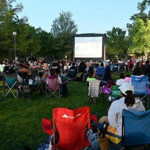 People watching an outdoor movie in an Oak Lawn park