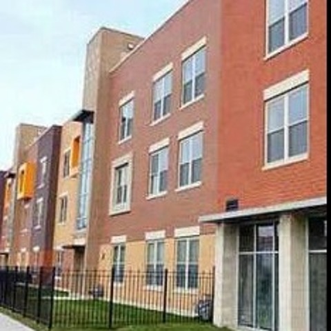 Red and blond brick exterior of a three story building offering income restricted two and three bedroom apartments.