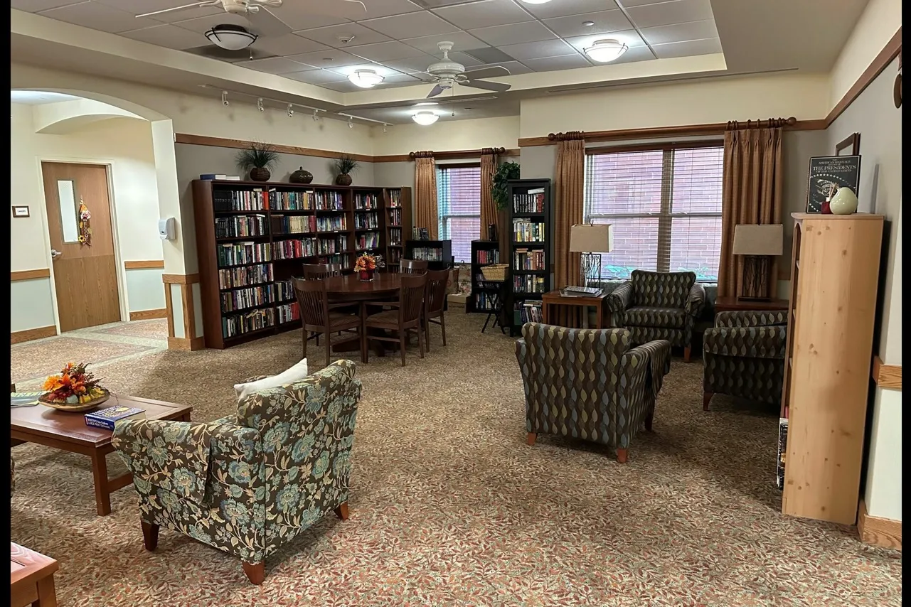 On site library with an assortment of books and stuffed chairs.