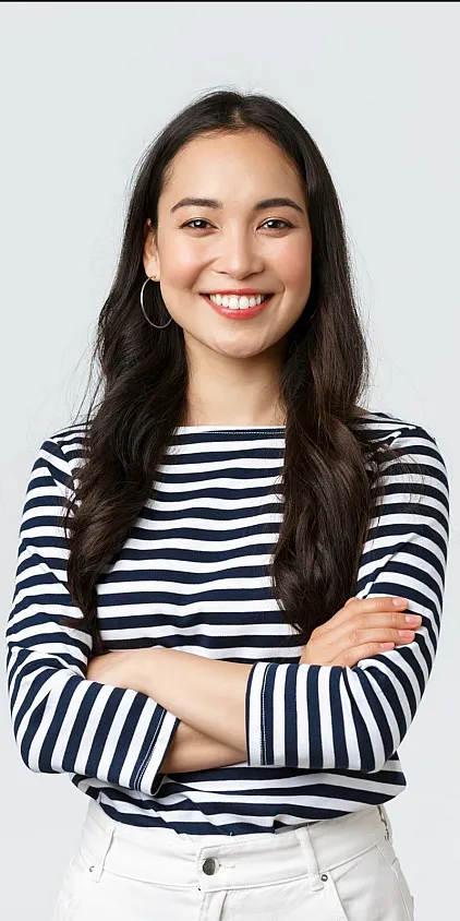 A smiling female prospective resident with arms folded in a black and white striped shirt.