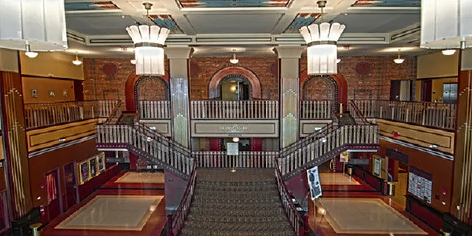 Interior of the nearby historic Paramount Theater with a grand staircase and one of a kind vintage light fixtures.