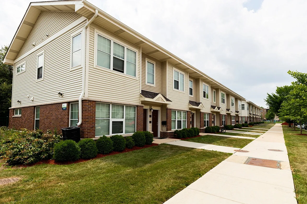 Exterior of Homan Square Phase 6 a two story brown brick and tan sided townhouse style apartment building complex.