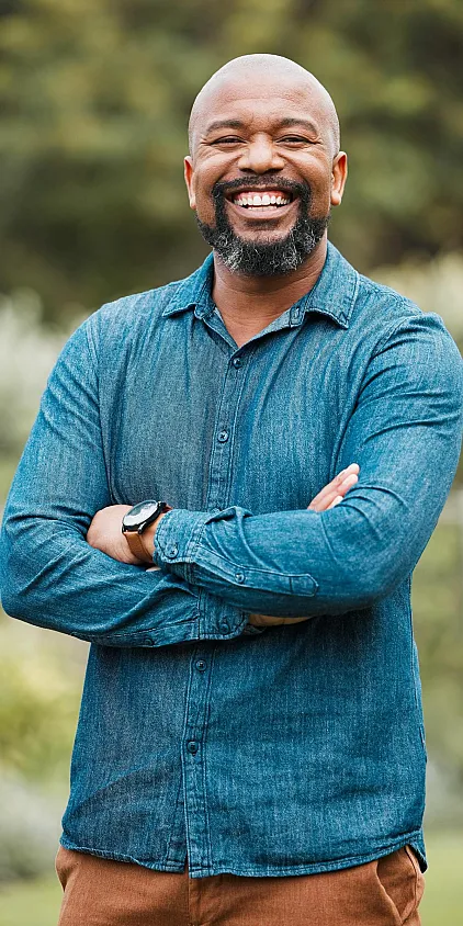 A smiling prospective senior resident in a blue shirt with his arms folded.