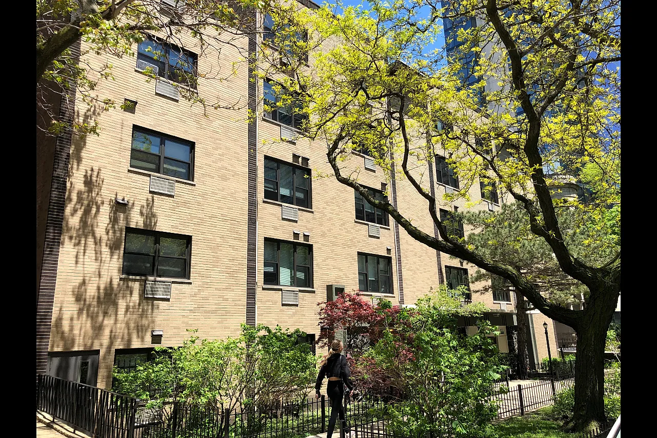 Exterior of 424 West Oakdale a fifty seven unit four plus one property with a yellow brick exterior and nicely landscaped front yard in Lakeview.