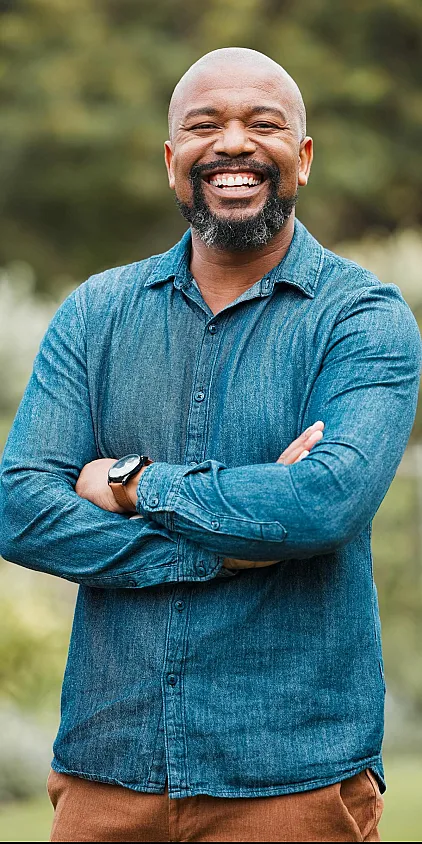 A smiling prospective senior resident in a blue shirt with his arms folded.