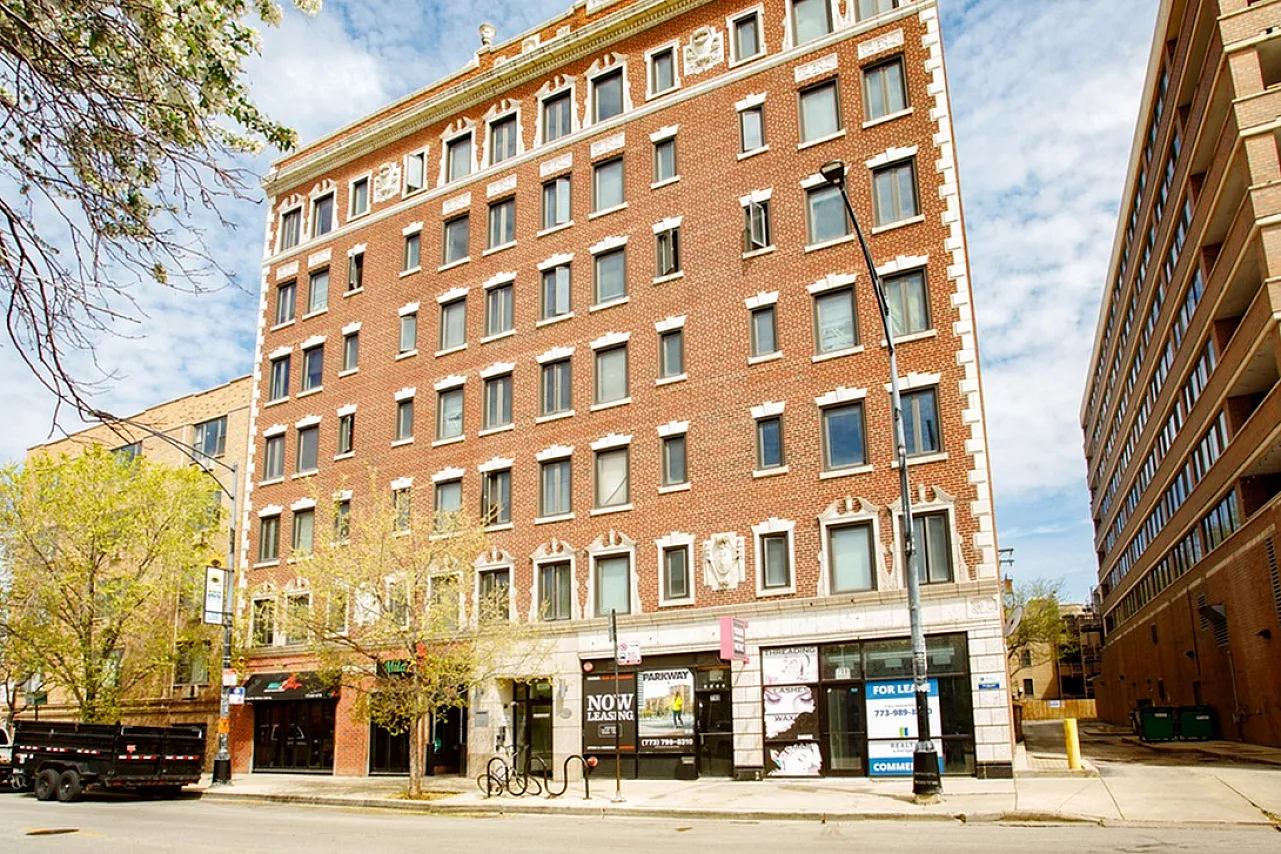 Seven story red brick apartment building with 1st floor retail