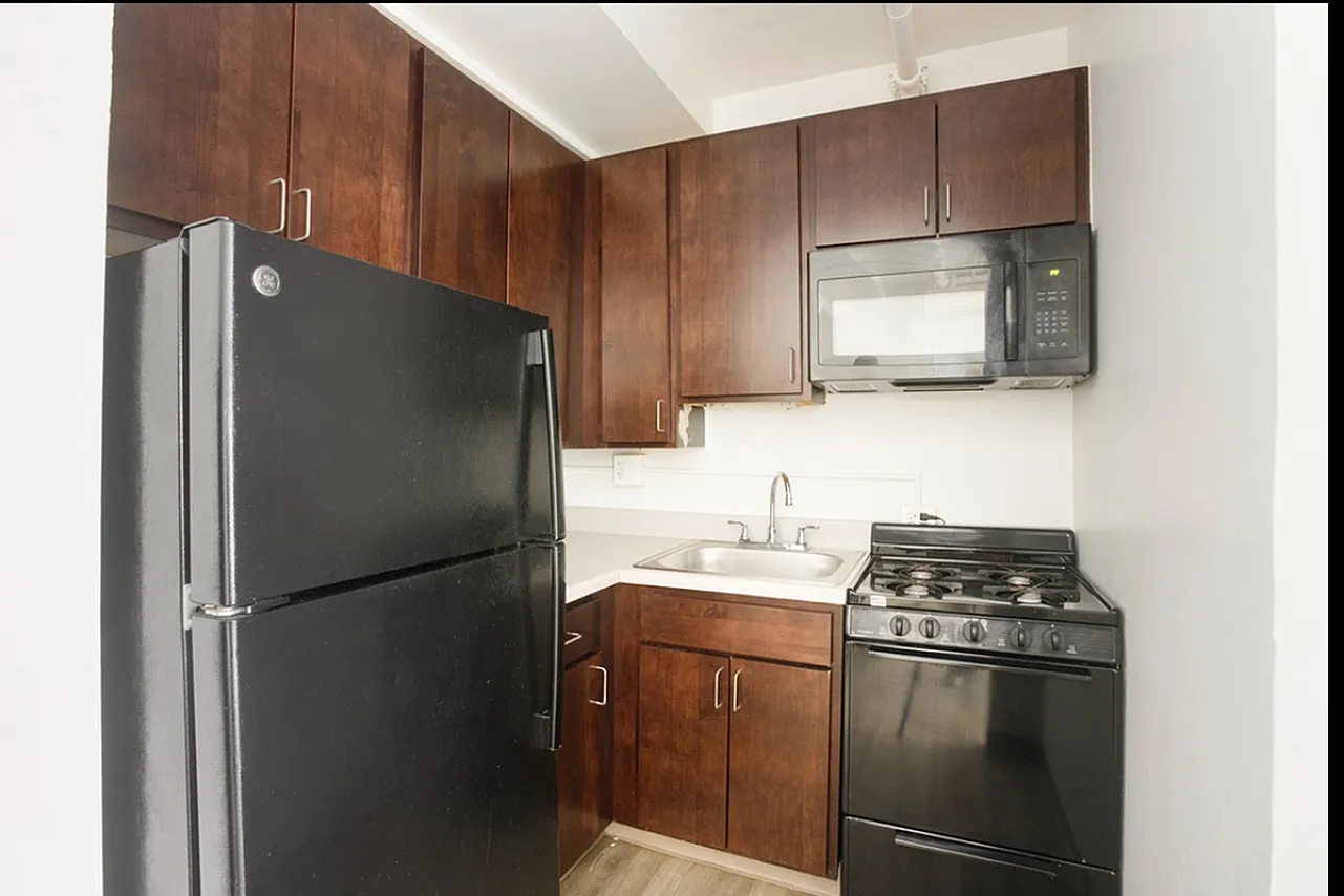 Kitchen with dark cabinets and black appliances