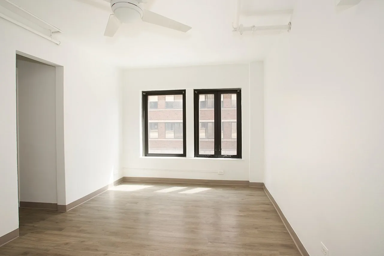 Apartment living room with ceiling fan and large windows