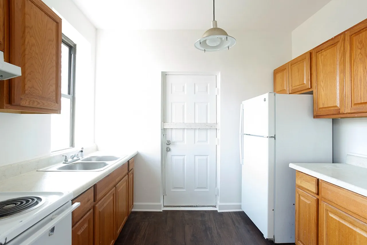 Kitchen with back door and natural wood cabinets