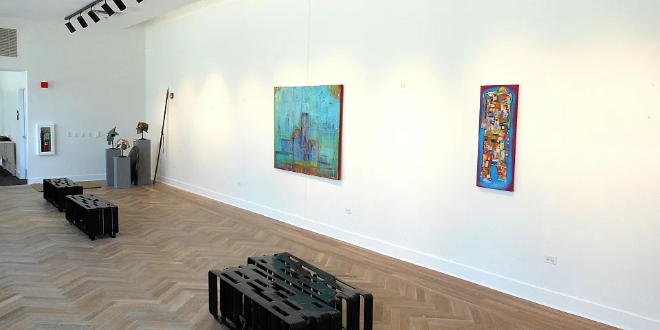 Large room housing an art gallery with 2 paintings on the wall