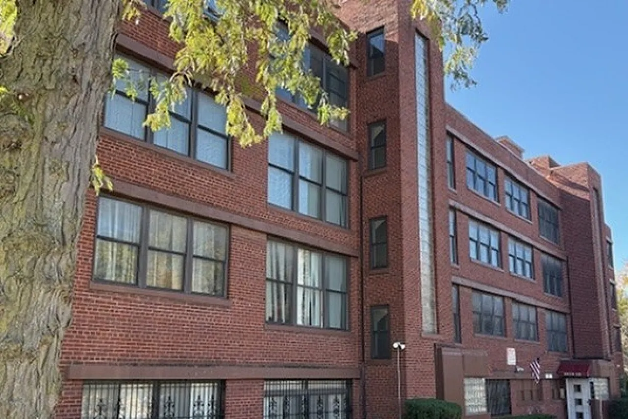 Red brick apartment building with glass block and art deco doors