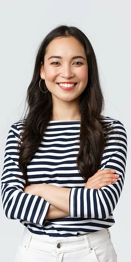 A smiling prospective resident in a striped shirt with her arms folded.