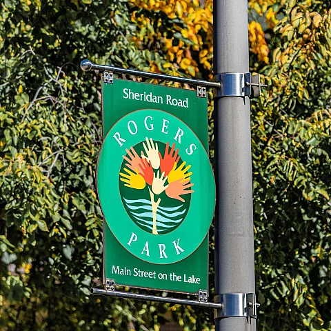 Green Rogers Park banner hanging on a streetlight post