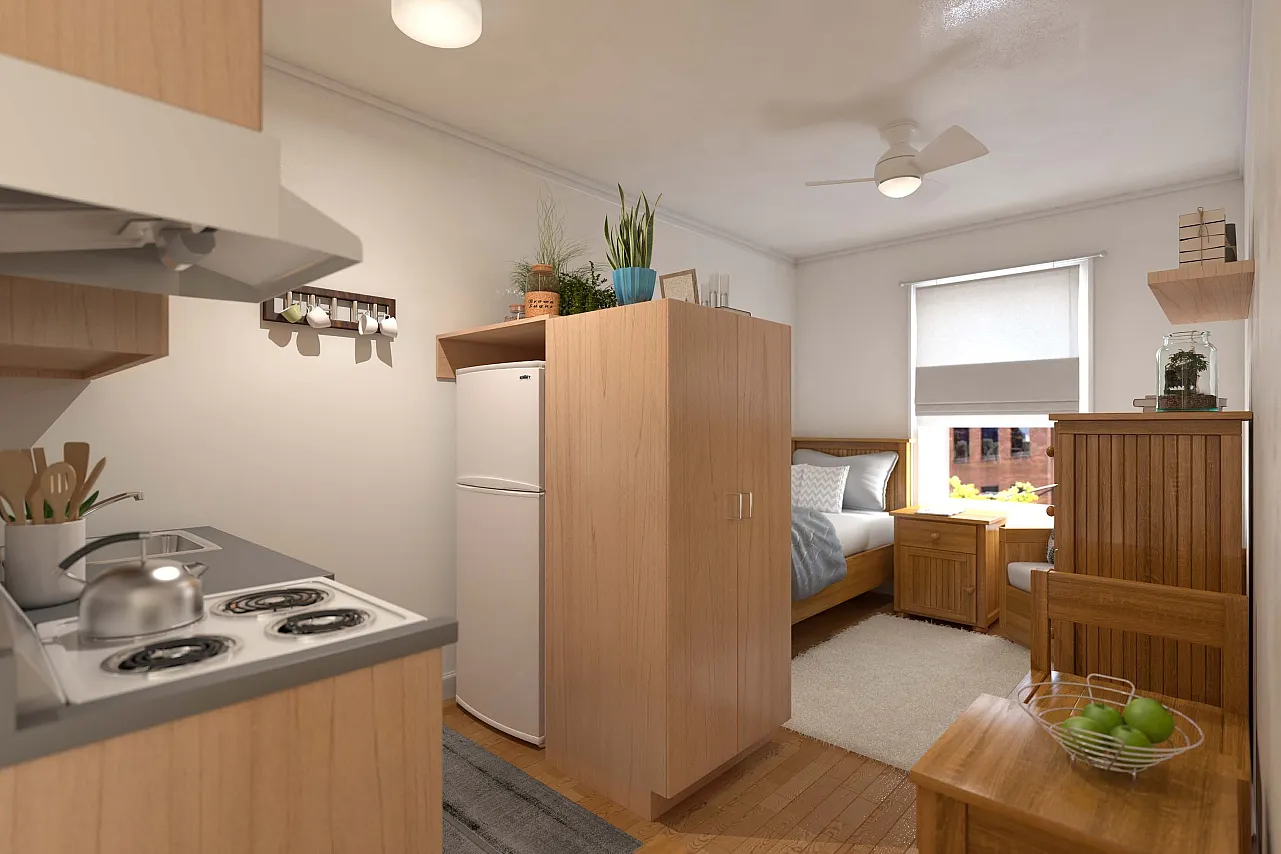 An income restricted studio apartment with a ceiling fan, electric appliances, and wooden furniture.