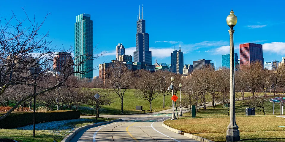A paved bike path along Lake Michigan under a blue sky.