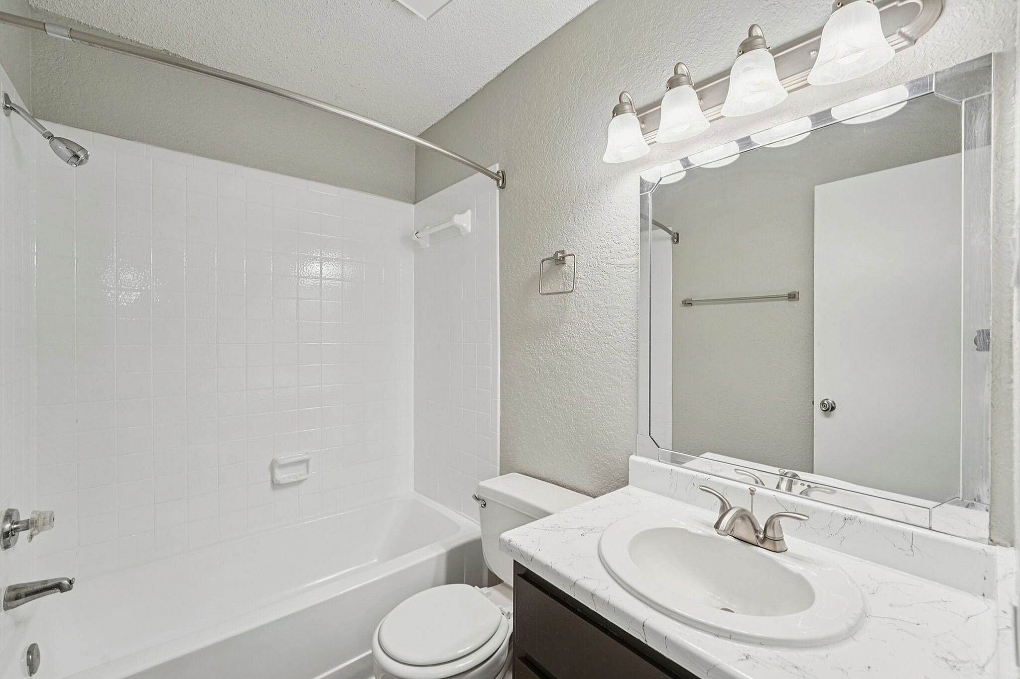 bright and clean bathroom with tub and shower