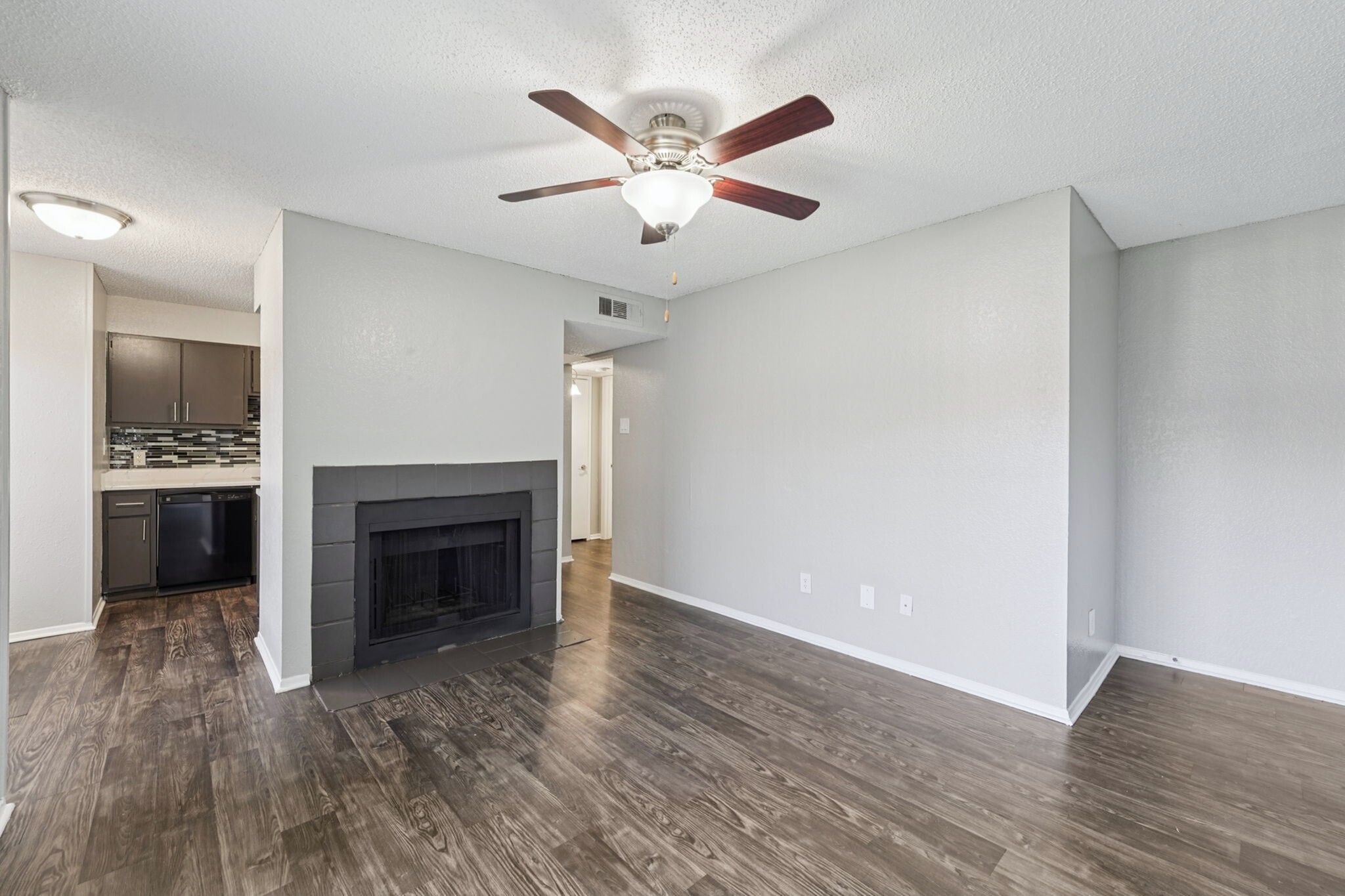 wood burning fireplace in the living room with ceiling fan