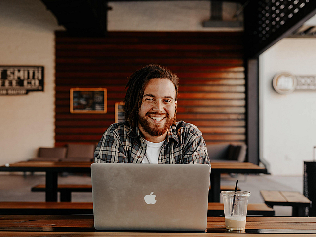 gentleman working on an mac in a cafe