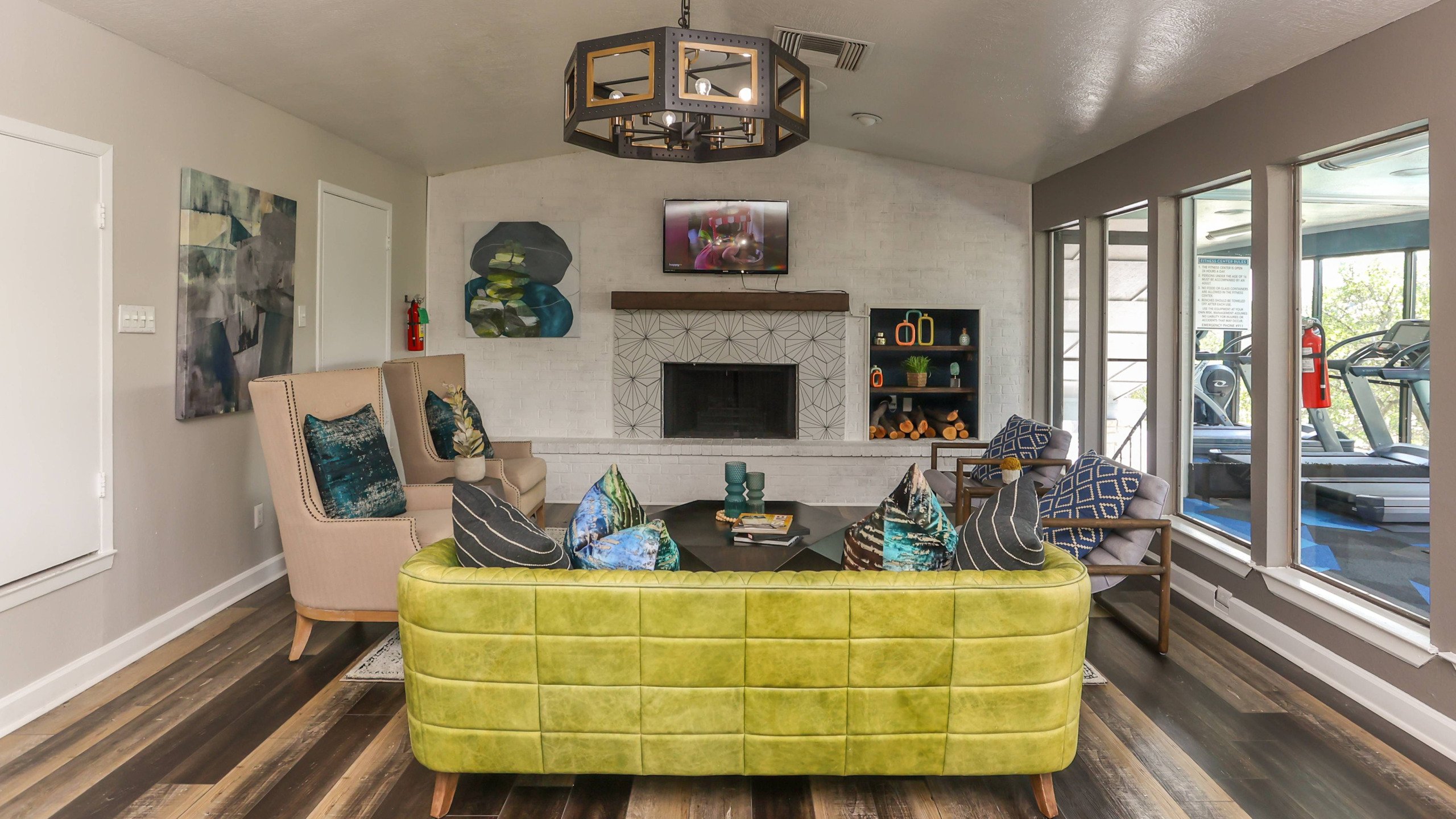 stylish clubhouse with fireplace next to the fitness center