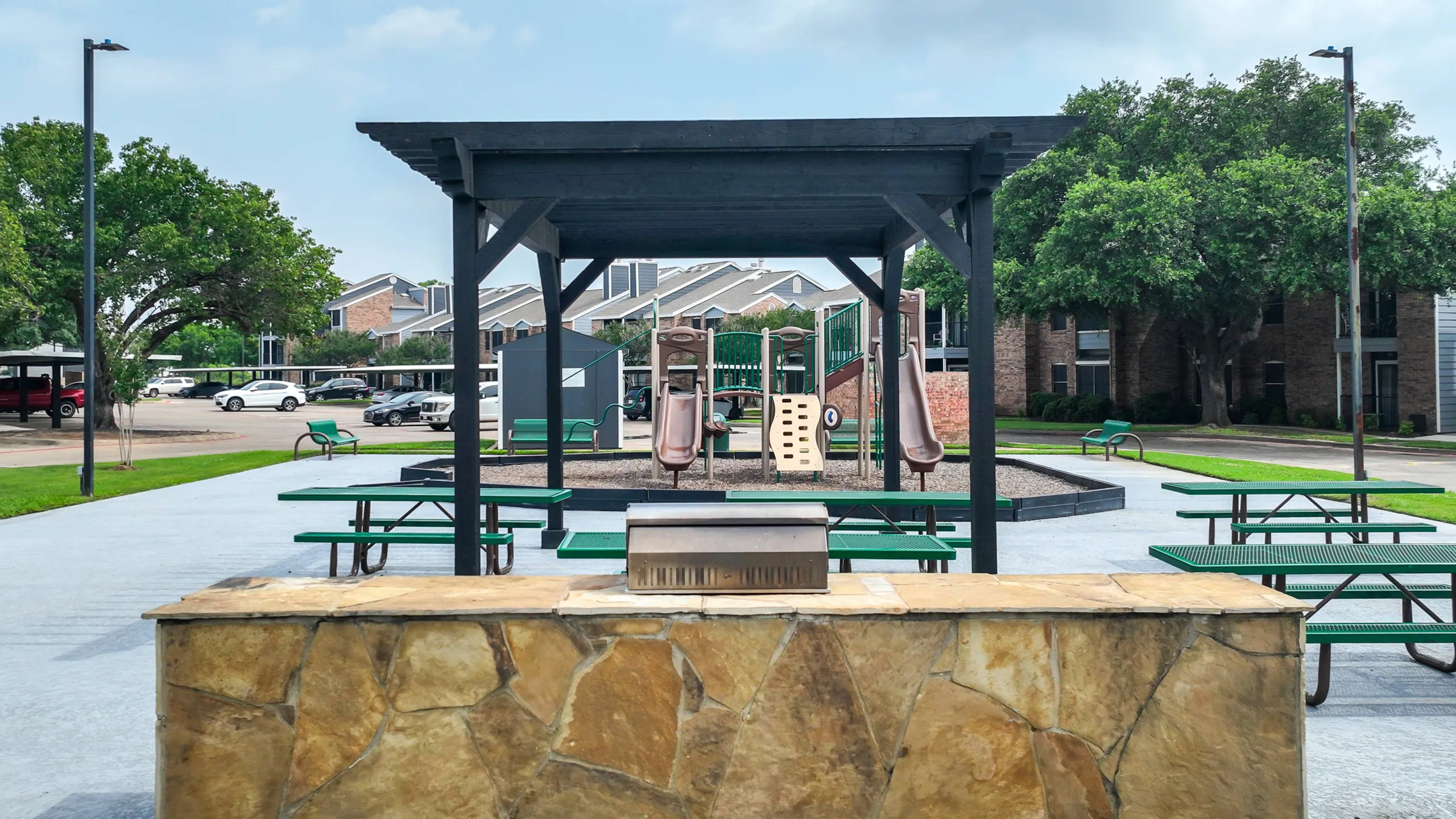 outdoor grill and seating area beside the playground