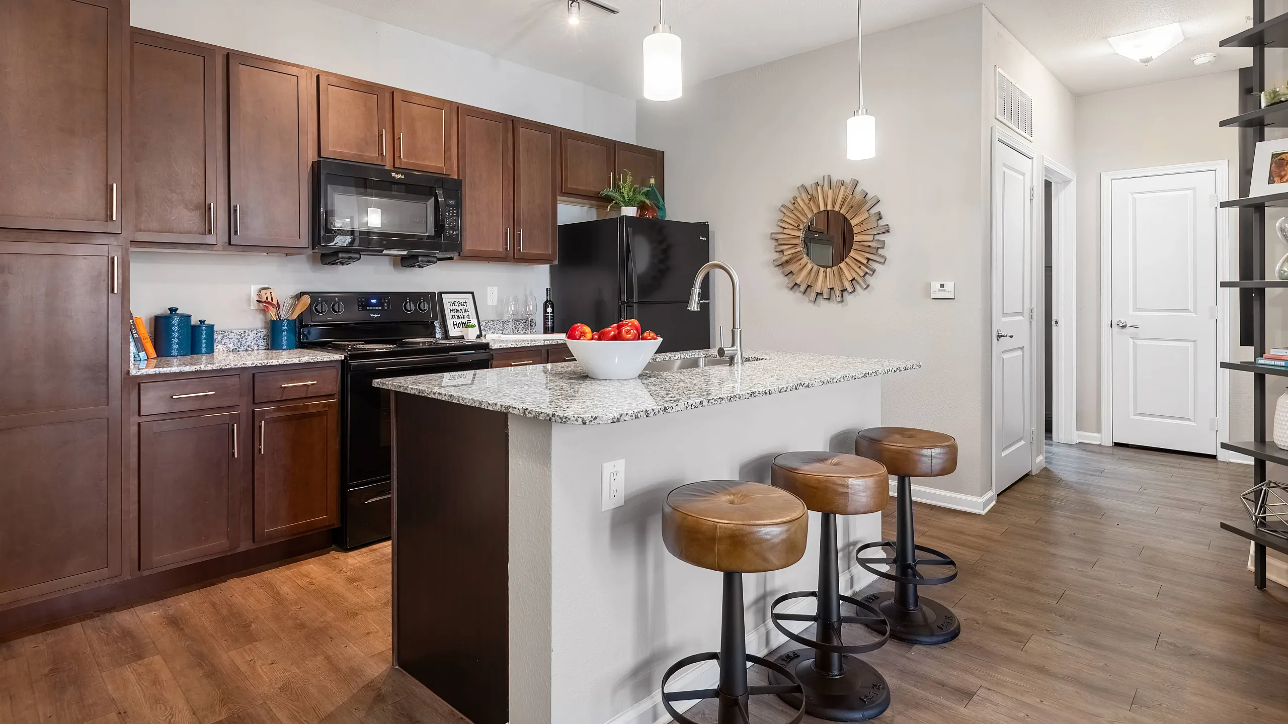 kitchen with black appliances and island with bar seating