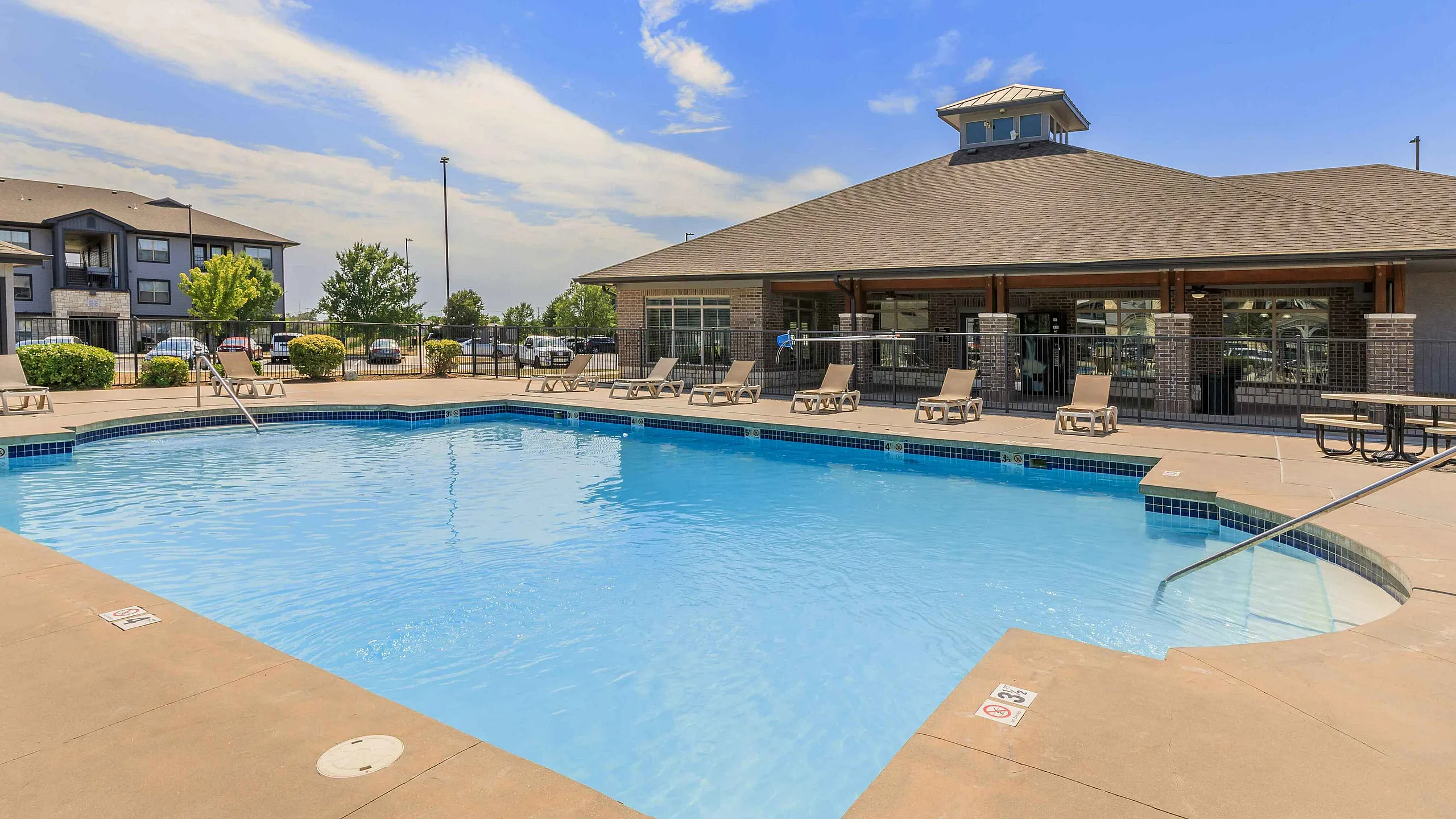 sparkilng pool with lounge seating beside the clubhouse