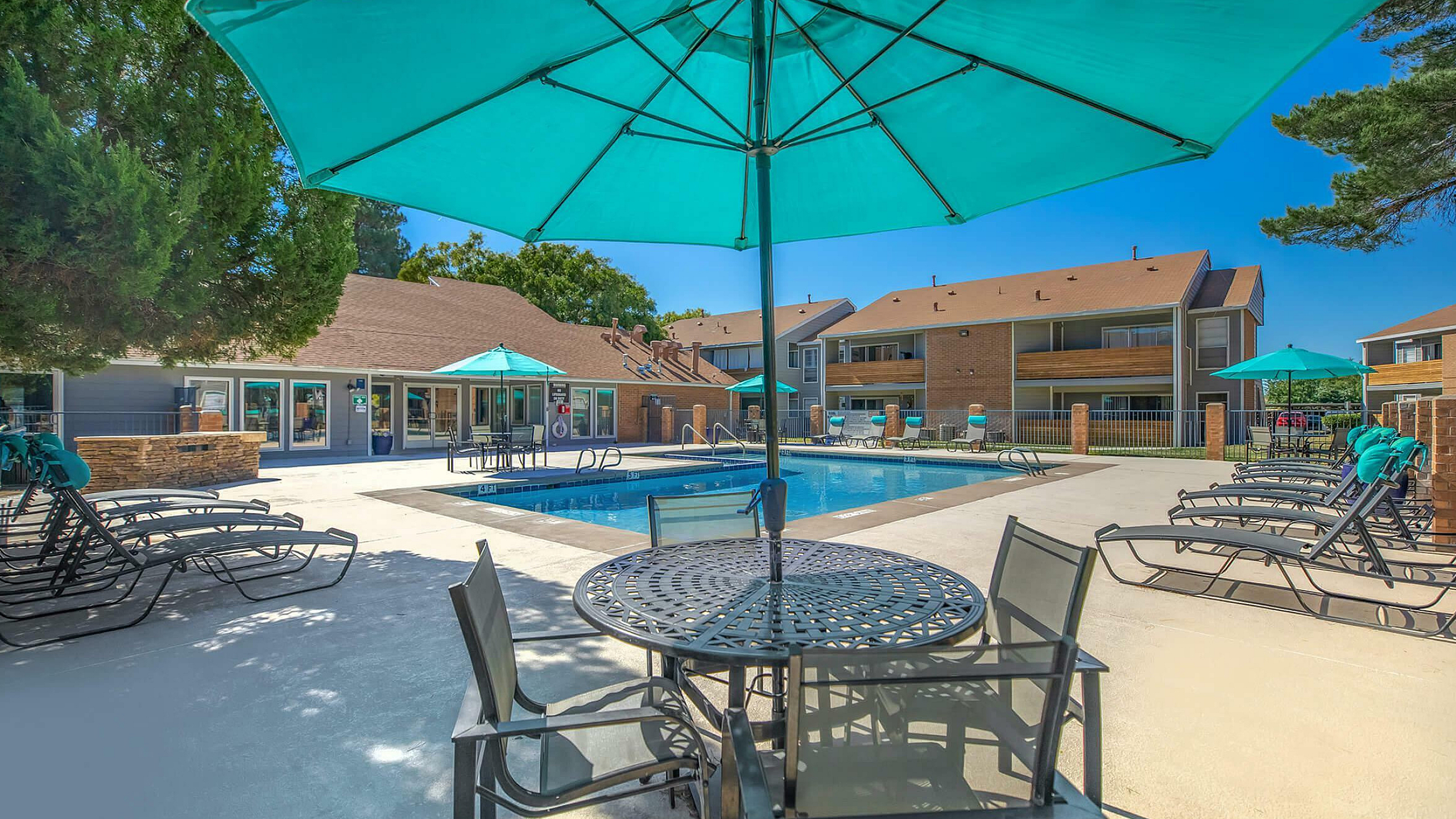sparkiling pool with shaded seating and lounge chairs