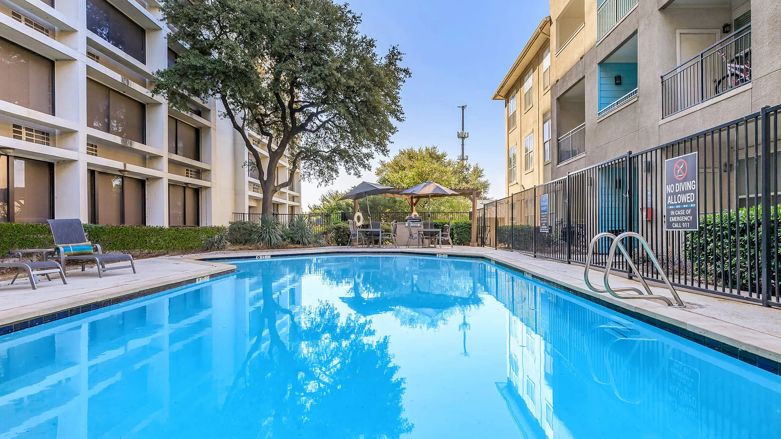 sparkiling resort style pool with outdoor grill