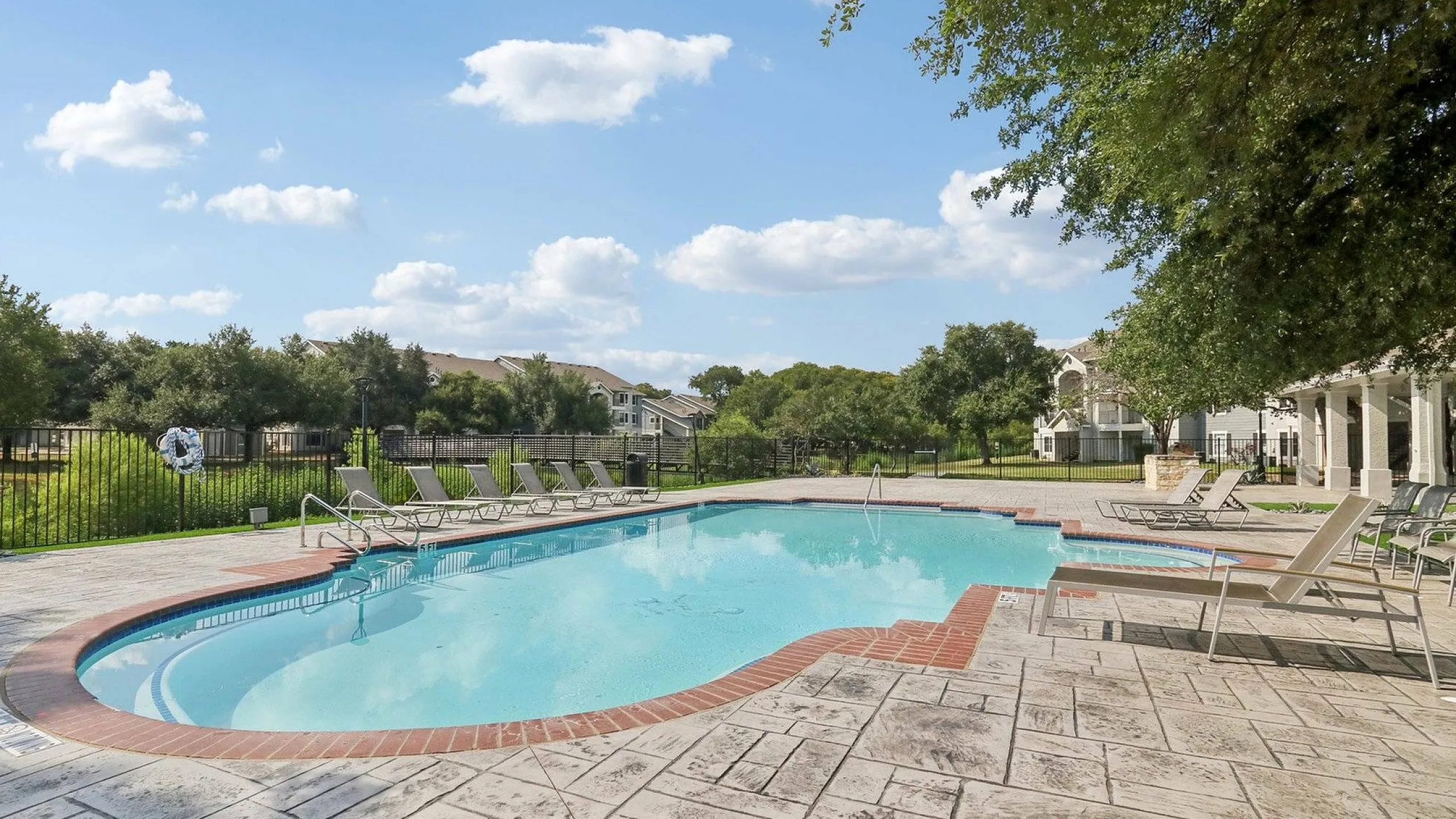 Swimming Pool Surrounded by Greenery and Lounge Chairs in Austin Texas