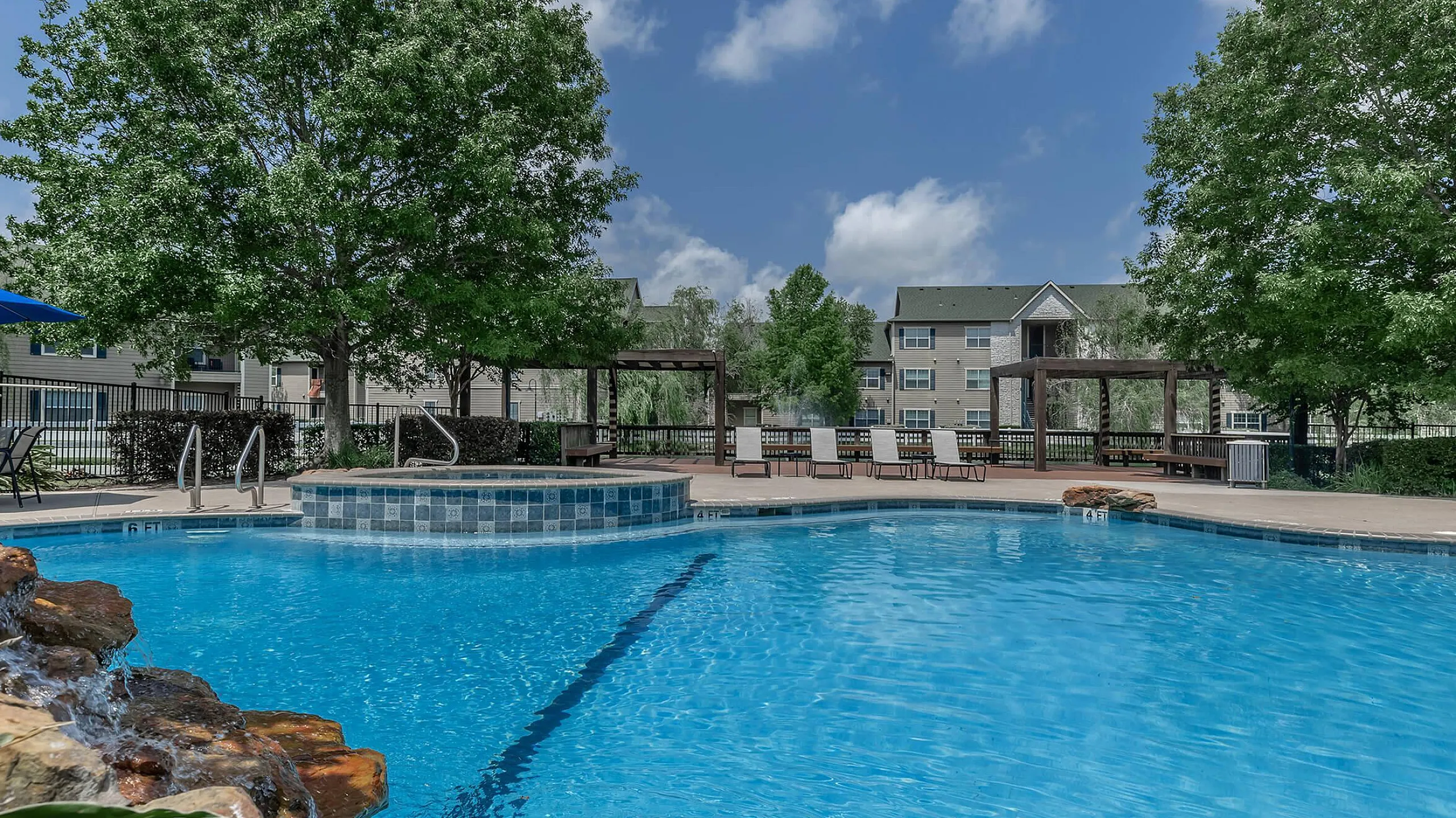 sparkiling resort style pool with lounge seating