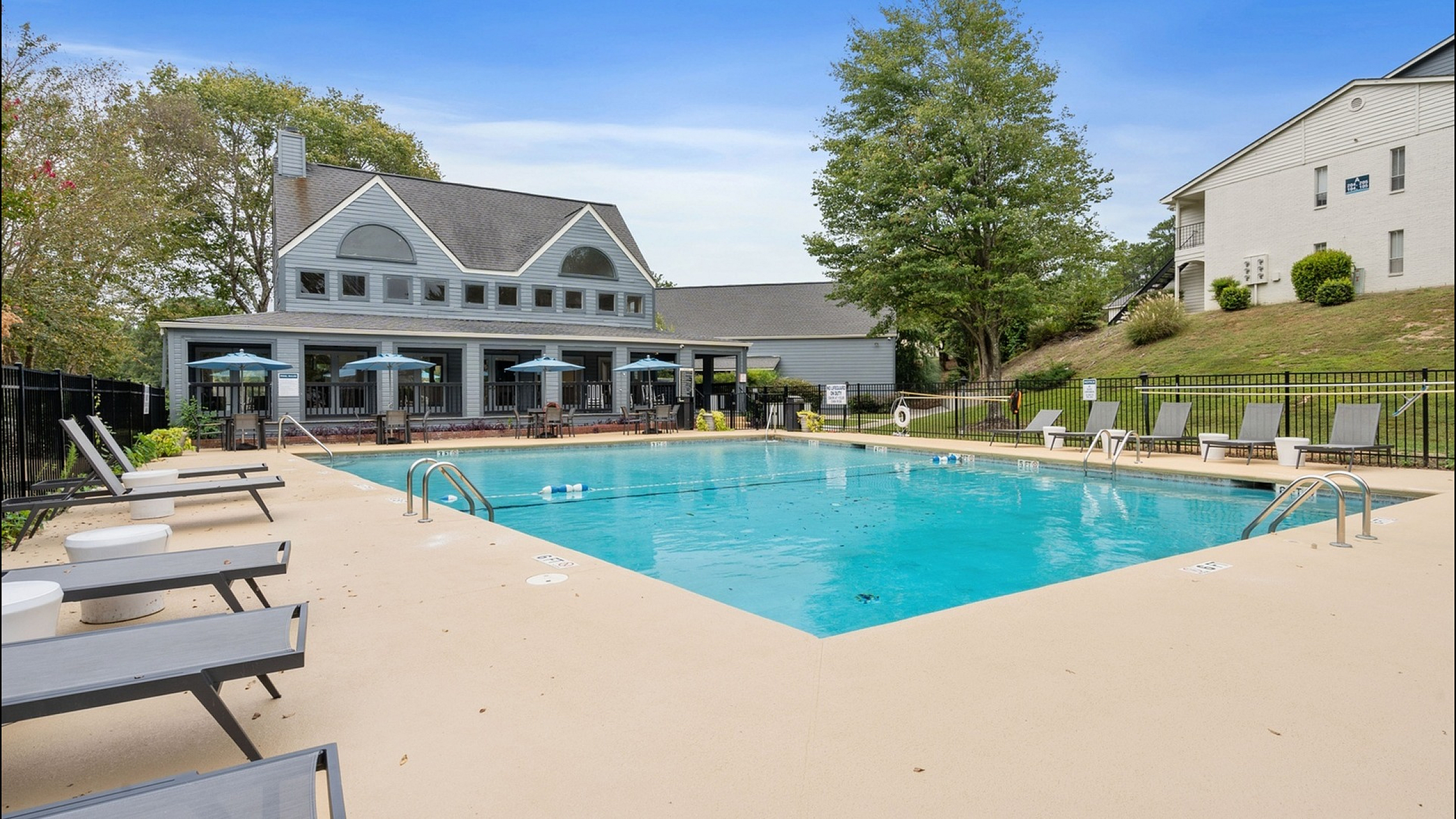 sparkilng pool with lounge seating beside the clubhouse