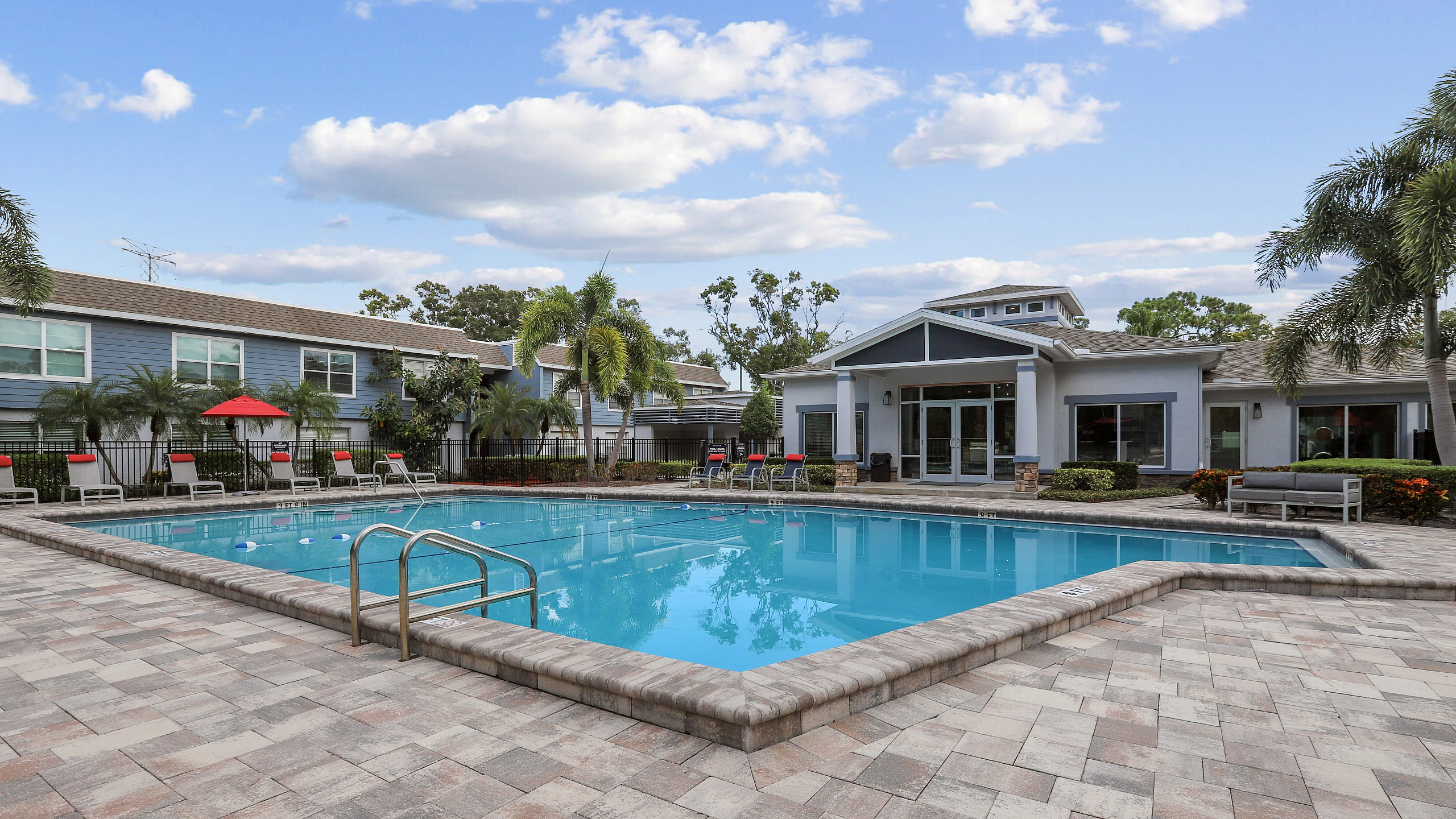 sparkling pool beside the clubhouse with concrete tile and lounge areas