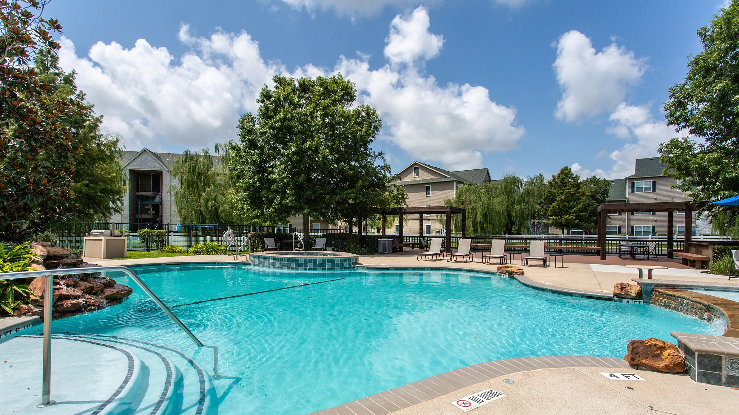sparkling resort style pool with lounge seating