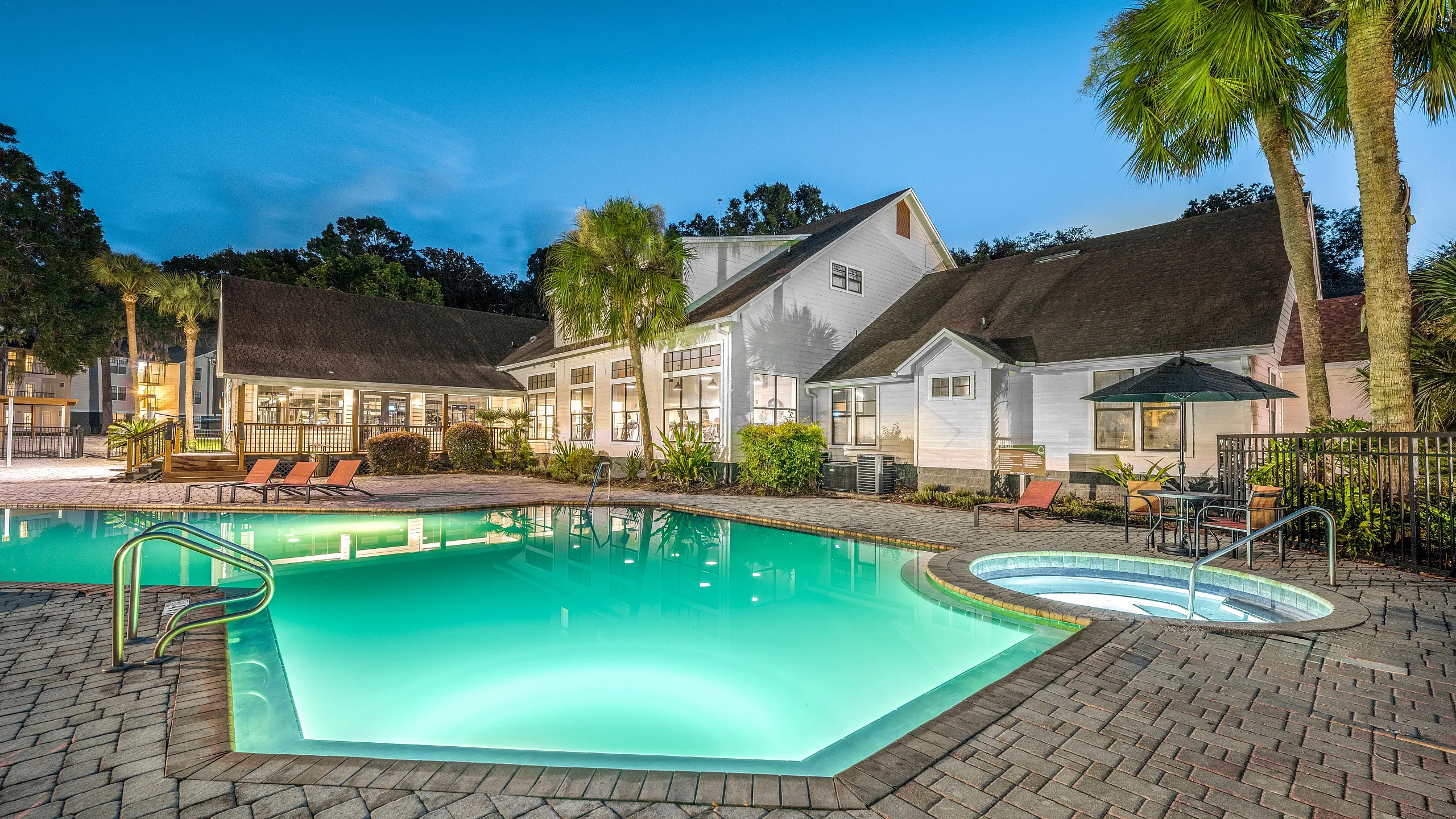 resort style pool at sunset with lounge seating
