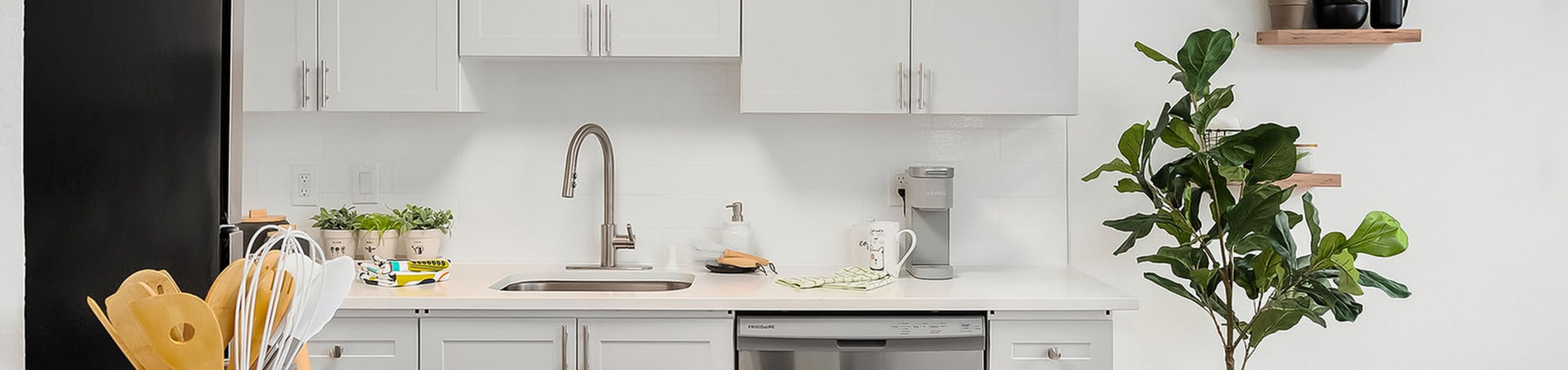 white kitchen cabinets and countertop with stainless steel appliances