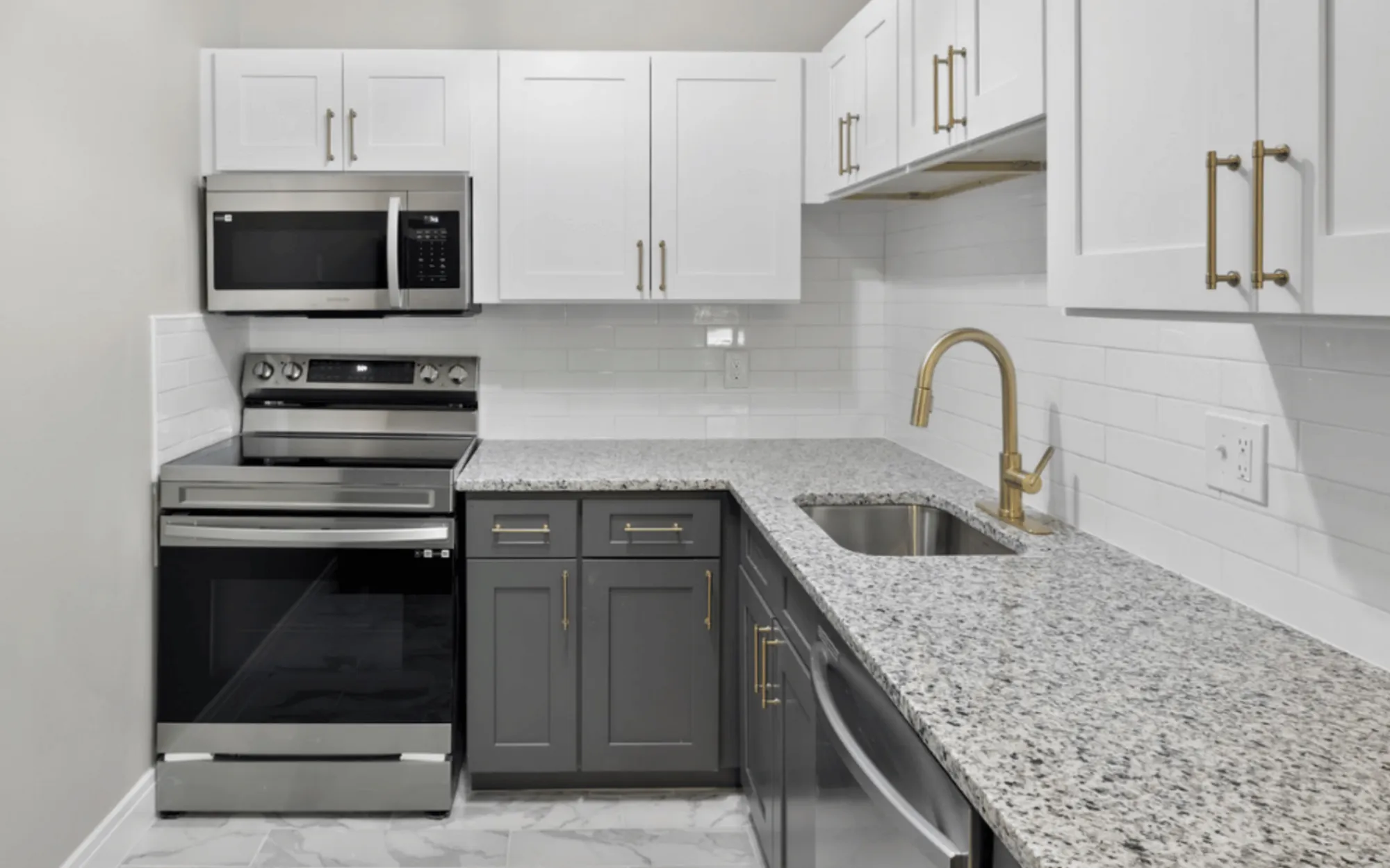 Contemporary kitchen with granite countertops, white cabinets, and stainless steel appliances.