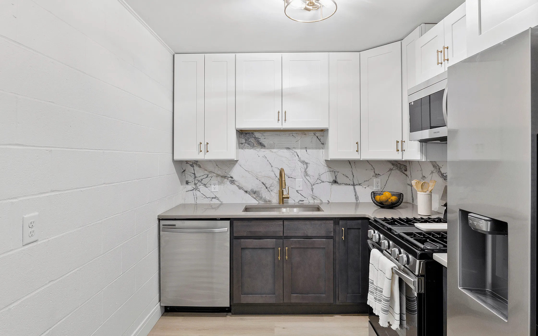 Modern kitchen with elegant marble backsplash, sleek stainless steel appliances, and chic white cabinetry.