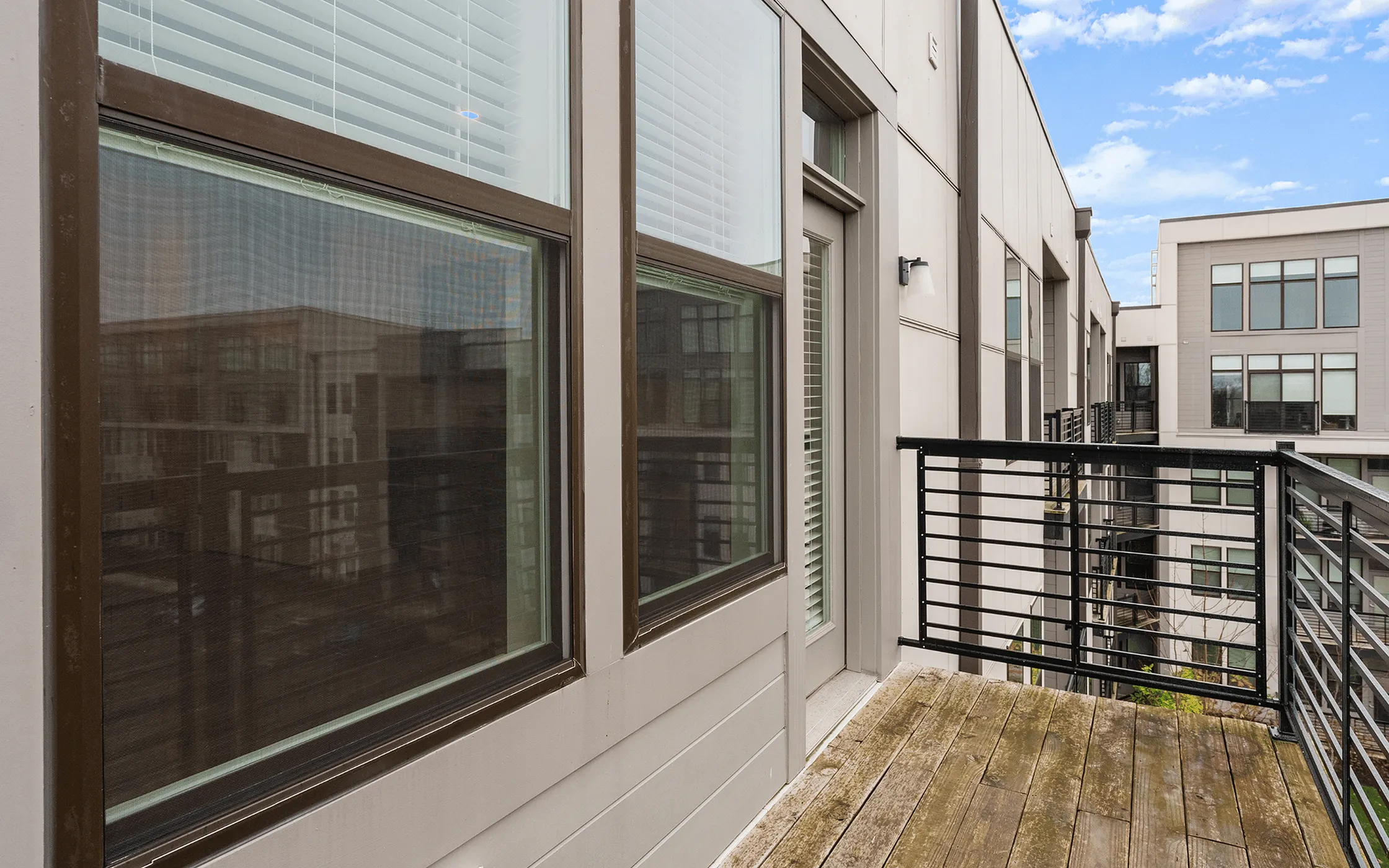 Inviting urban balcony view with sleek railing and expansive windows, perfect for relaxing and enjoying the cityscape.