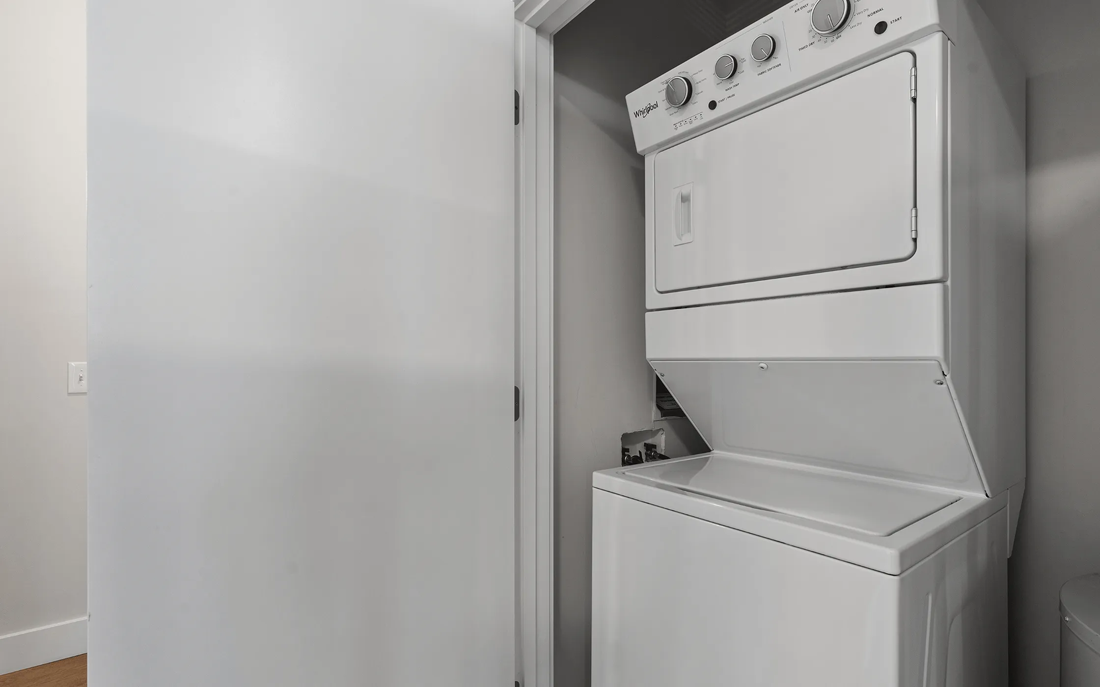 Modern apartment equipped with a stacked washer and dryer in a convenient laundry closet.