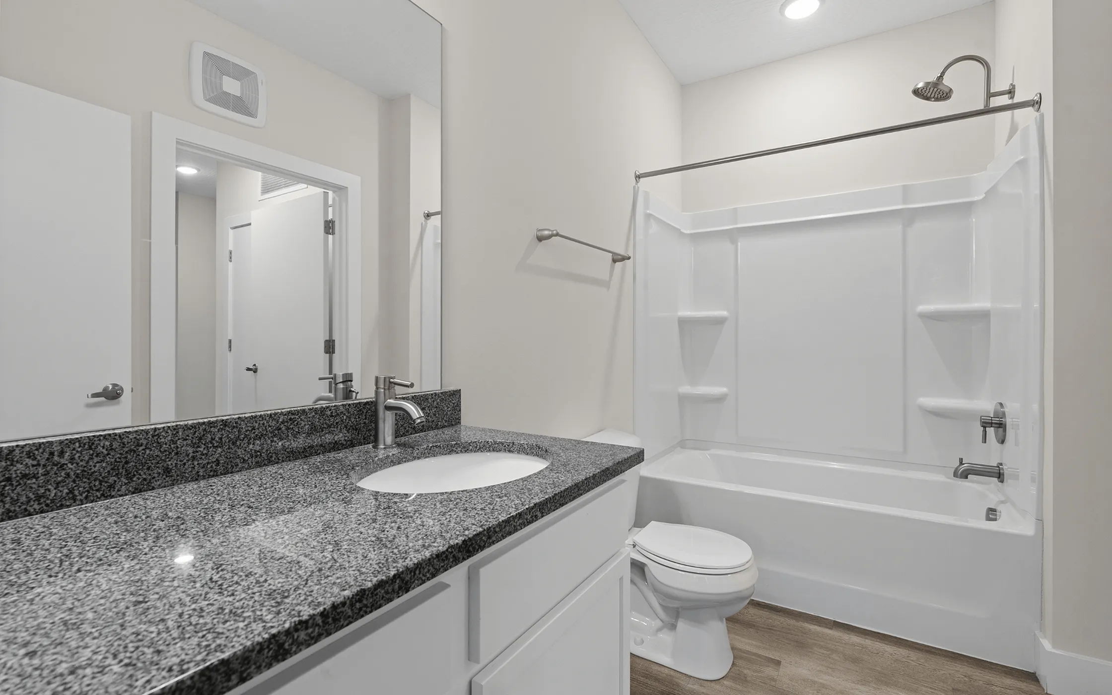 Elegant bathroom featuring a sleek granite countertop, modern sink, and a pristine white bathtub.