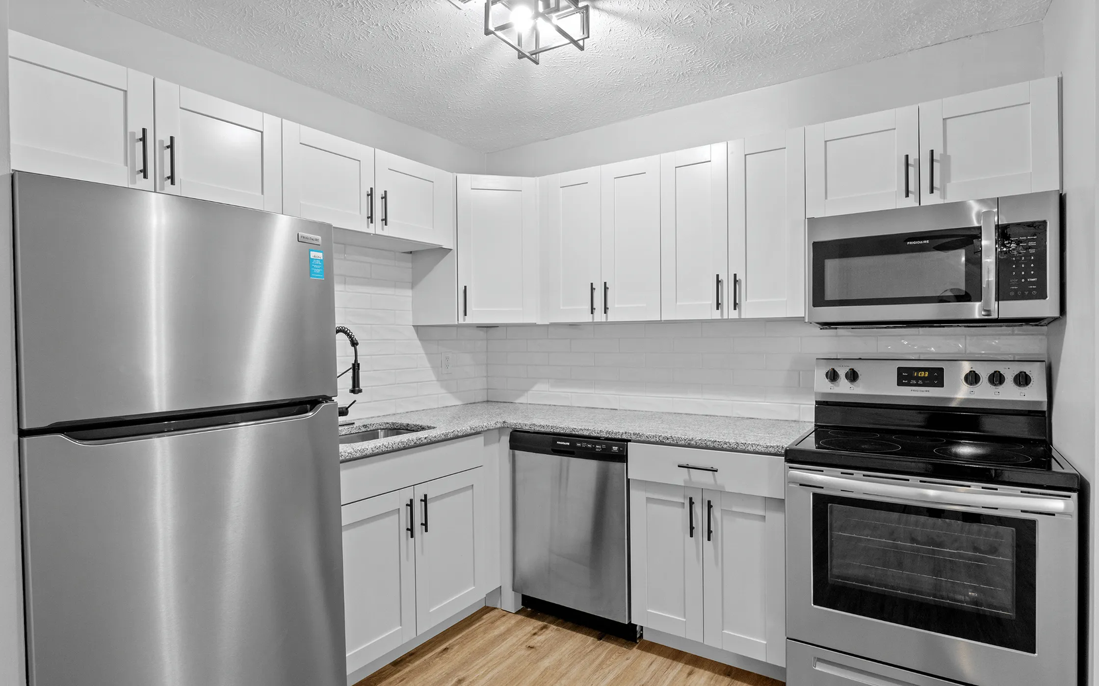 Modern kitchen featuring stainless steel appliances, sleek countertops, and elegant white cabinetry.