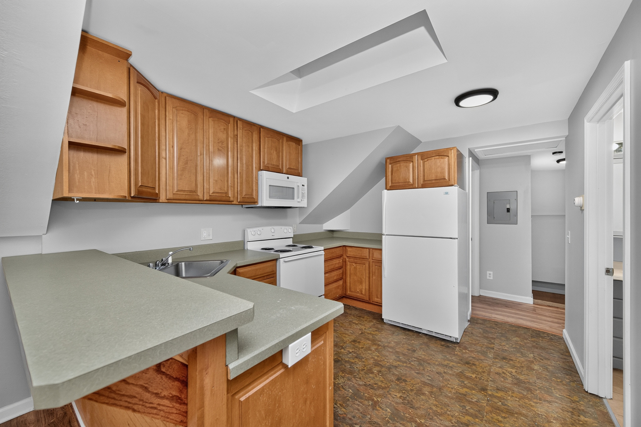 Charming kitchen with wooden cabinetry, modern appliances, and a cozy corner layout perfect for culinary creativity.